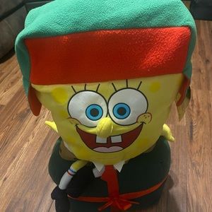Spongebob around 3ft tall sitting on a Holiday present with bendable arms.